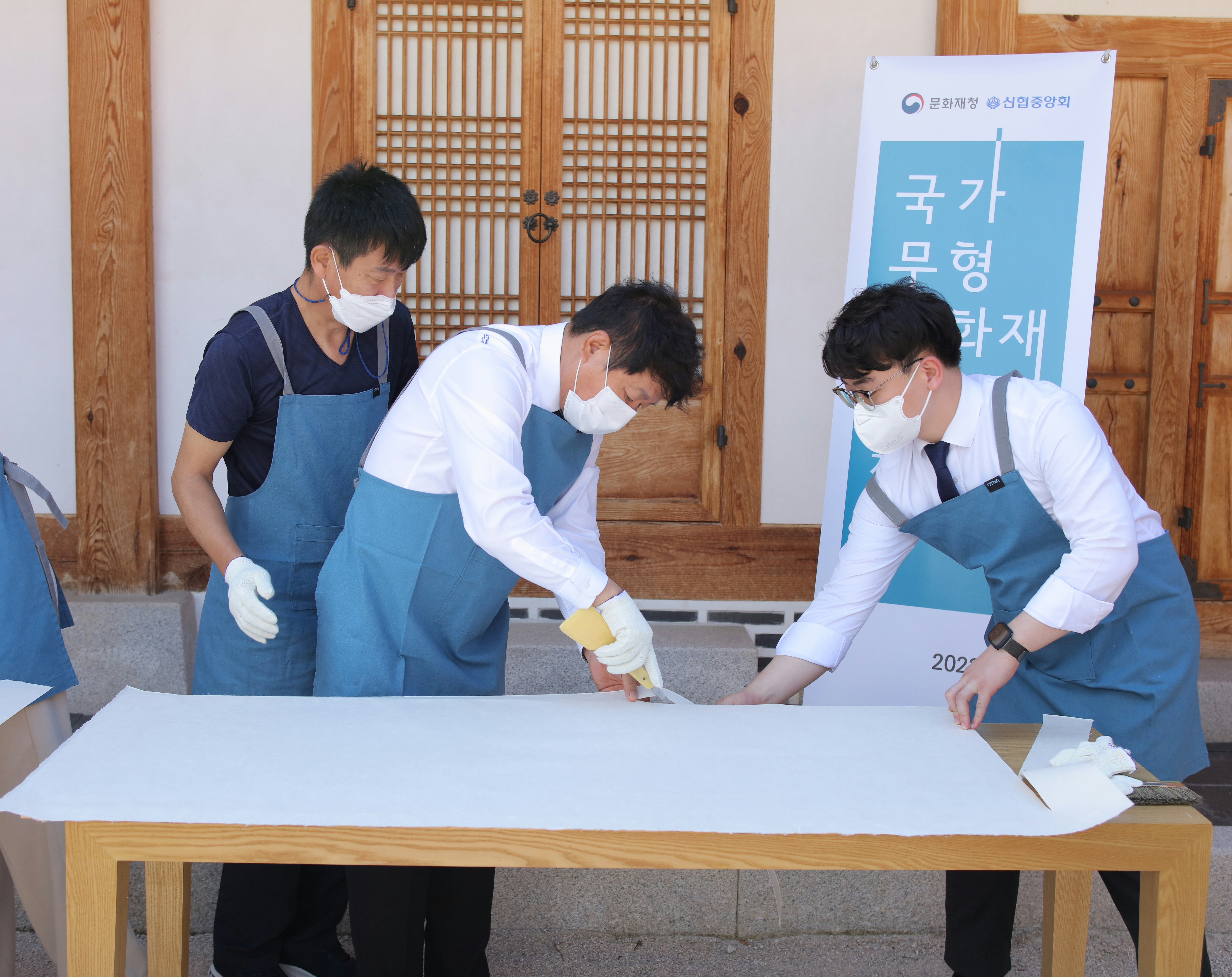 사진1. 신협이 지원하는 「전국 고택 관람환경개선 전통한지 지원 사업」에 참여한 김윤식 신협중앙회장(가운데)과 전주한지협동조합 관계자가 전통 제조방식으로 한지를 제작하고 있다.